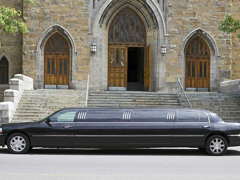 Luxury black stretch limousine waiting in front of a church Luxury black stretch limousine waiting in front of a church<br />