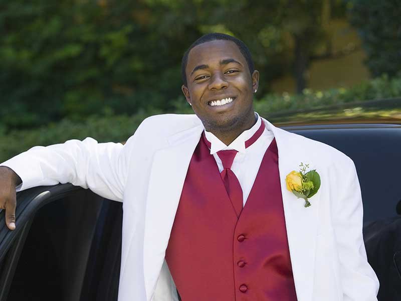 teen boy in a suit leaning on a limo ready for prom  teen boy in a suit leaning on a limo ready for prom<br />